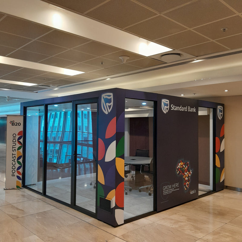 Modern office pod with colorful design and Standard Bank branding in a building interior.