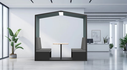 Modern office interior with a small meeting area featuring a table and chairs.